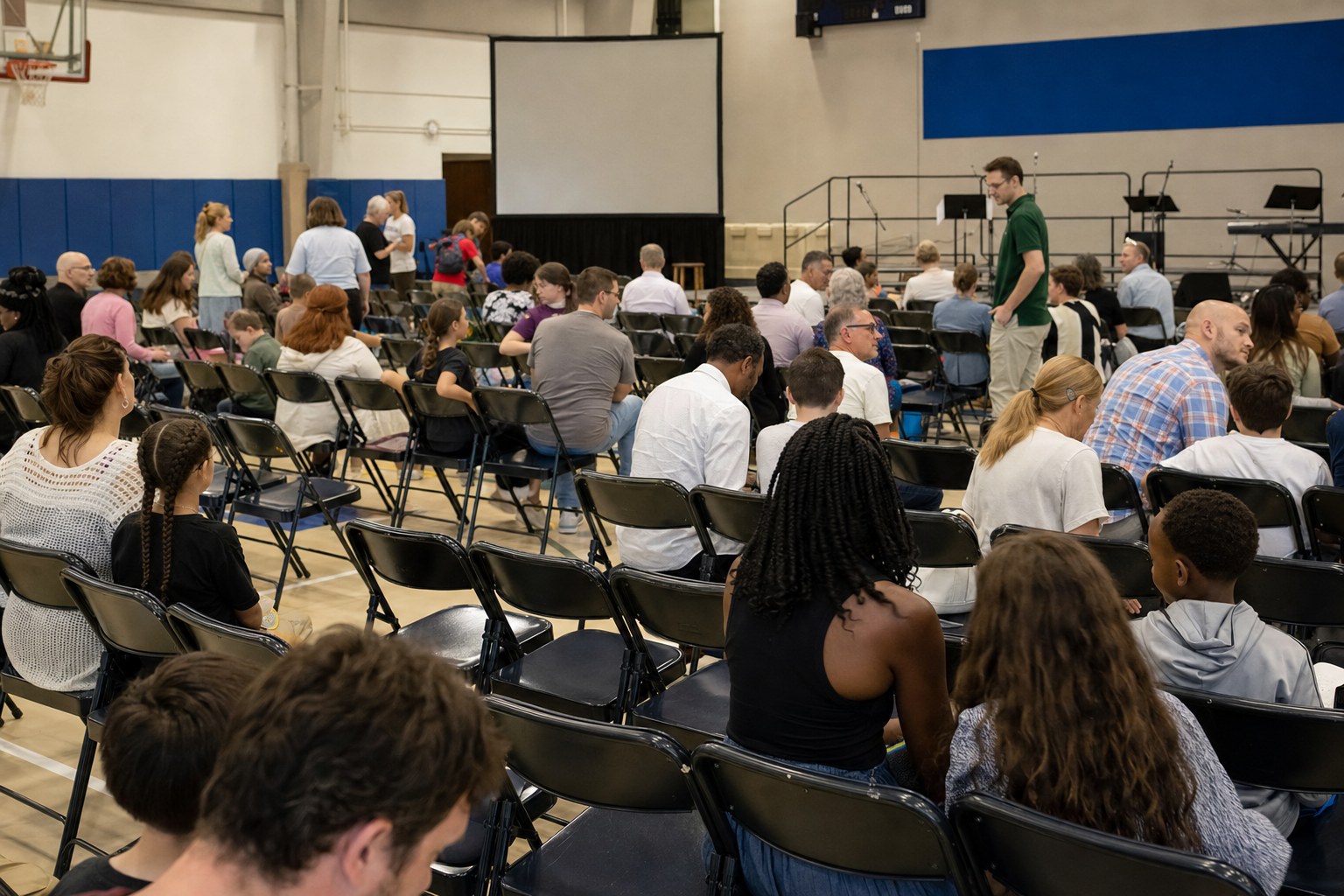 People gathering in a school gym before a Sunday service